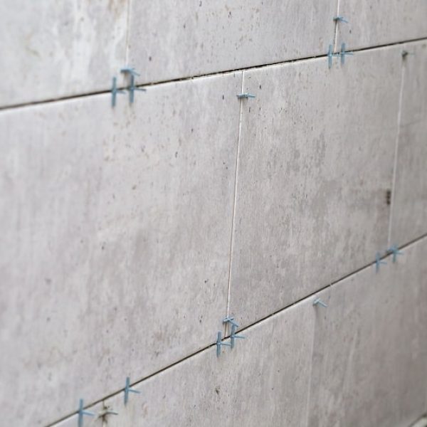 Tiles installation with spacers between ceramic tiles on the wall - renovation stage